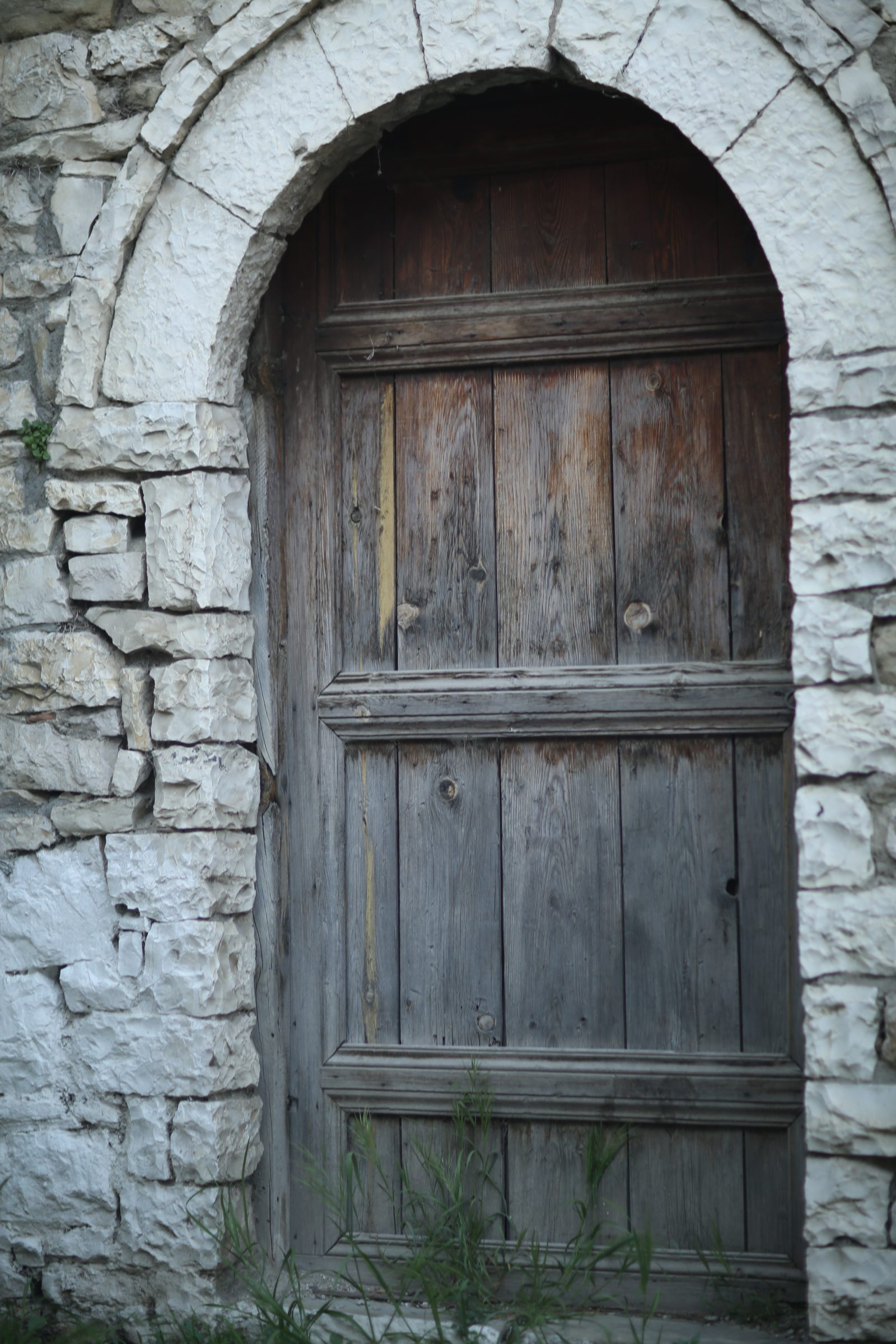 Arched Wooden Door in a Stone Wall