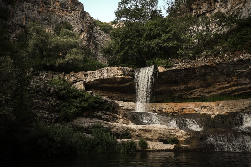 Layered Rock Waterfall in a Shaded Canyon