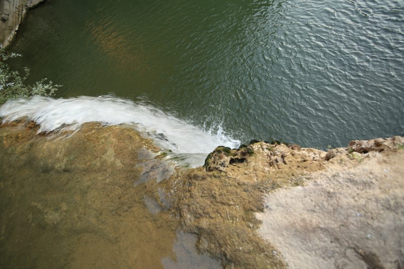 Waterfall Edge Above a Green Pool