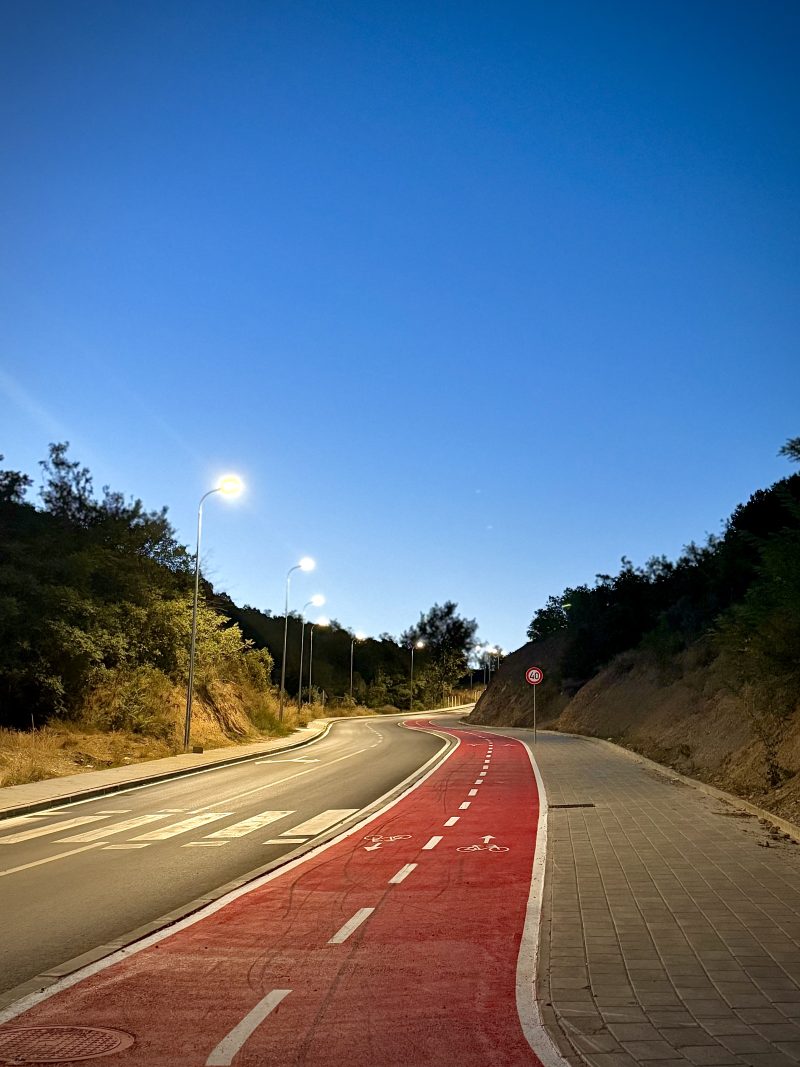 Road with a Red Bike Lane Under a Blue Sky