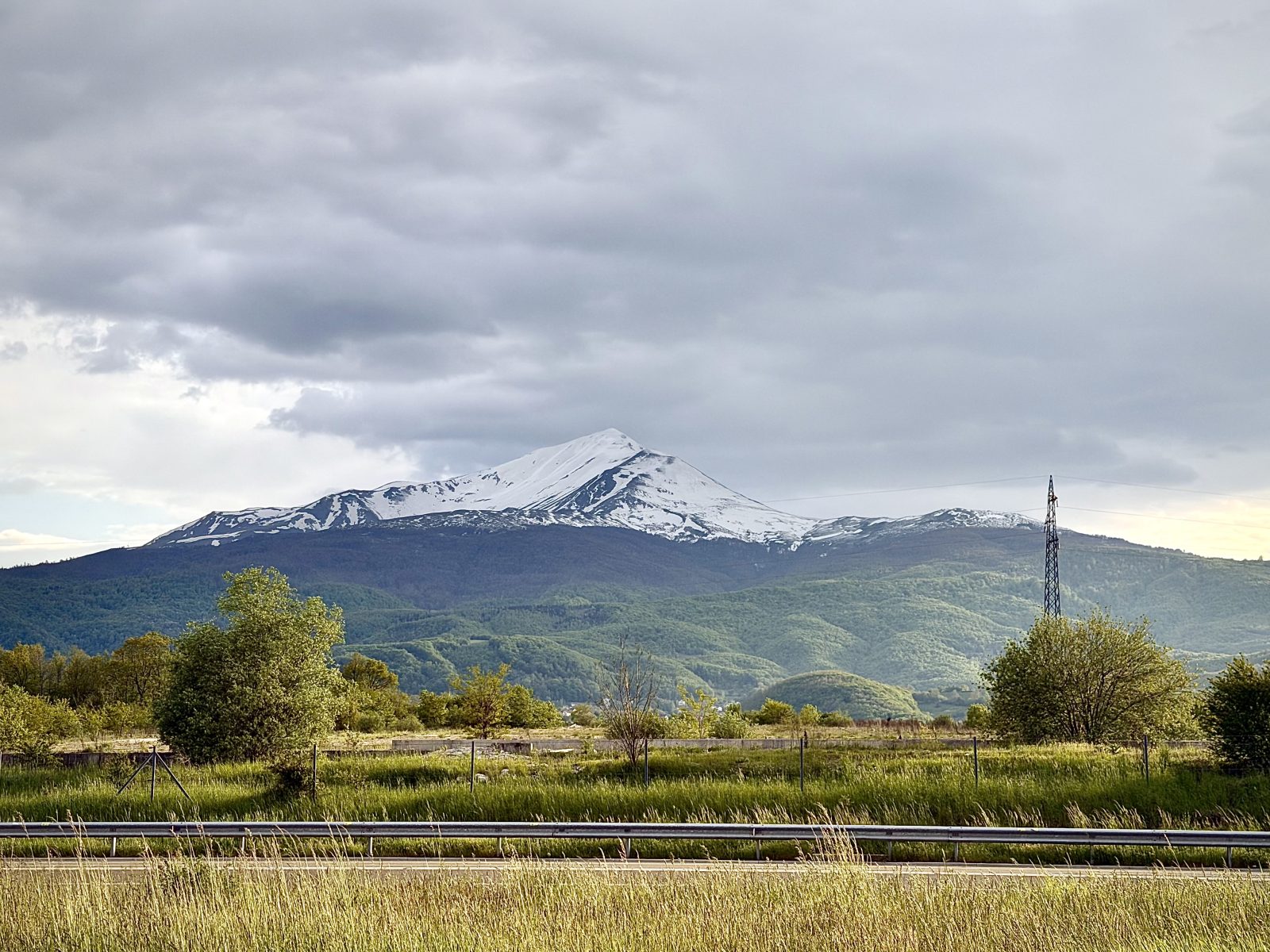 Snow-Capped Mountain Above Green Fields