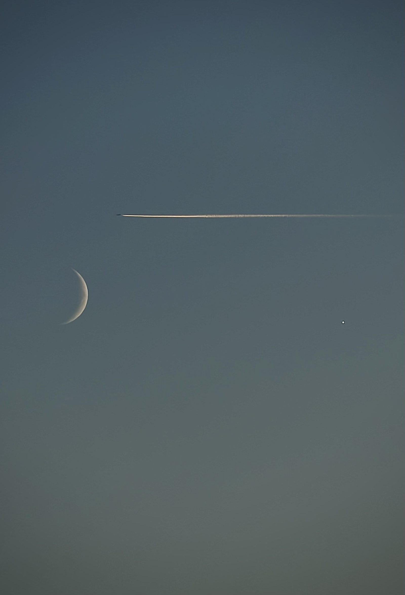 Thin Crescent Moon and a Plane Trail